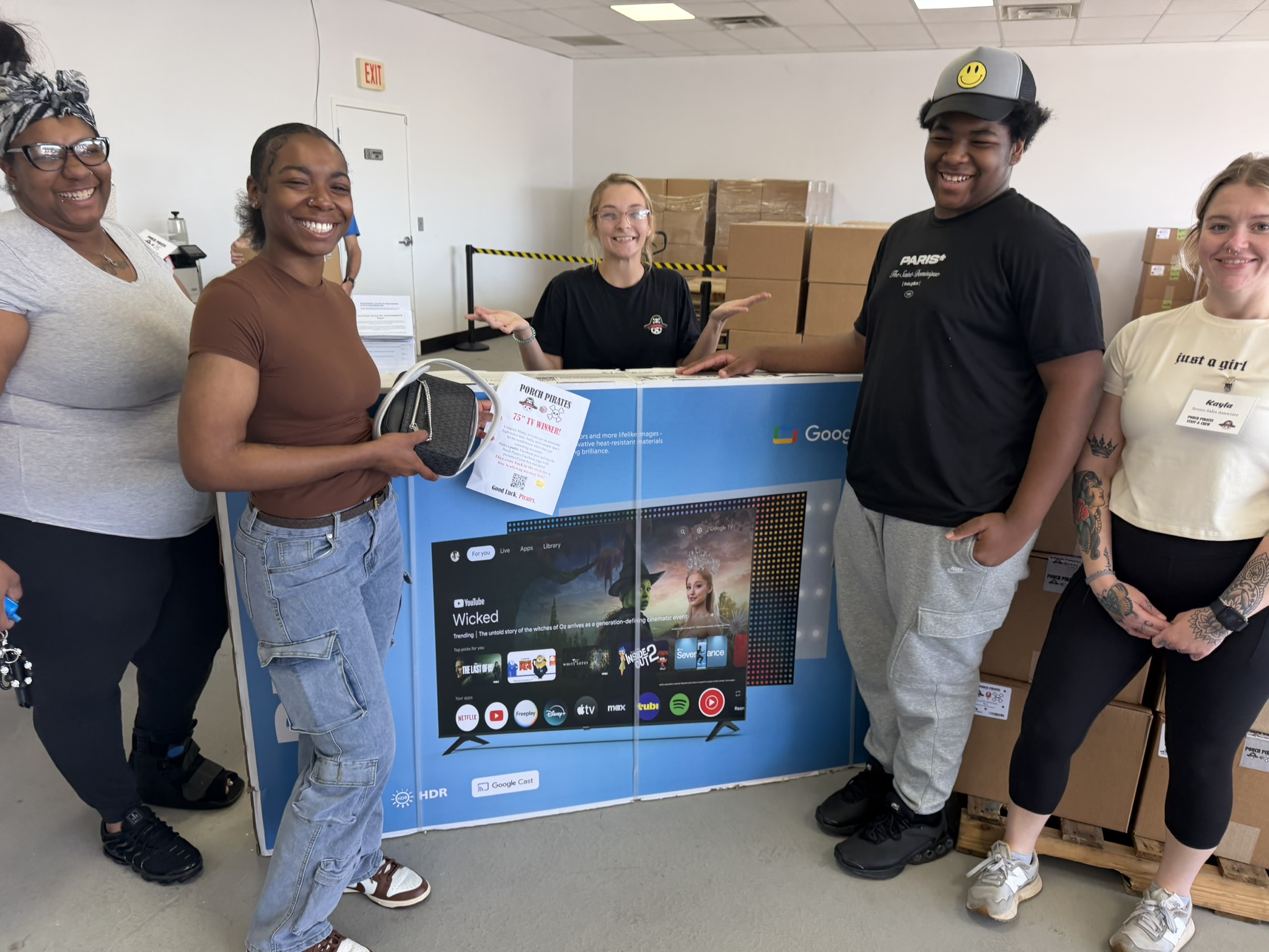 Group celebrating a 75 inch TV win in the store