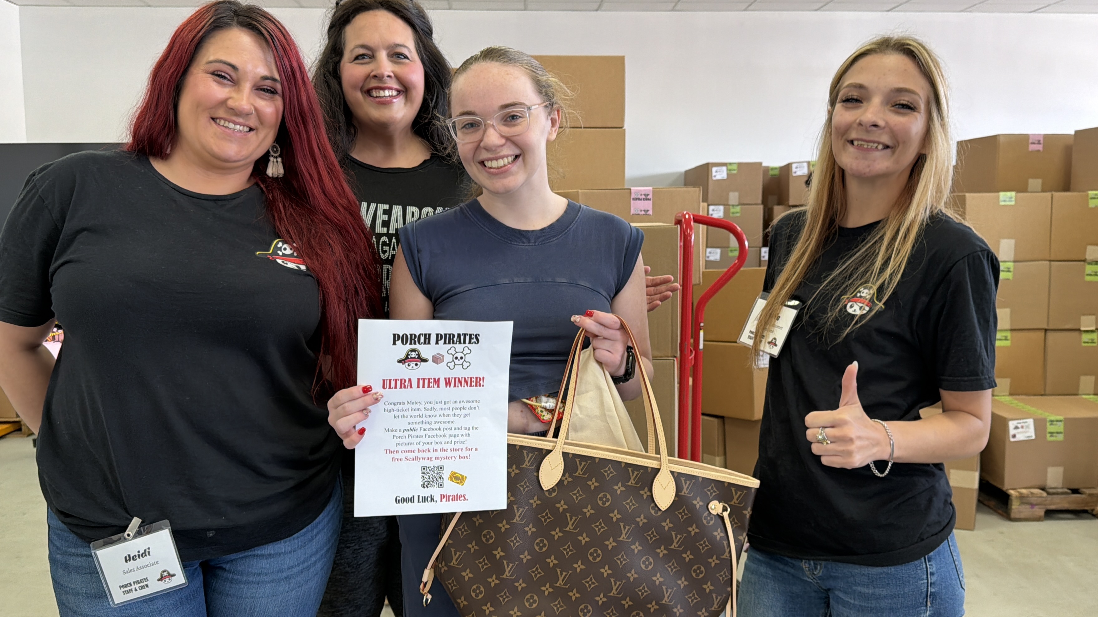 Customer with a Louis Vuitton tote and a winner sign, crew giving thumbs up
