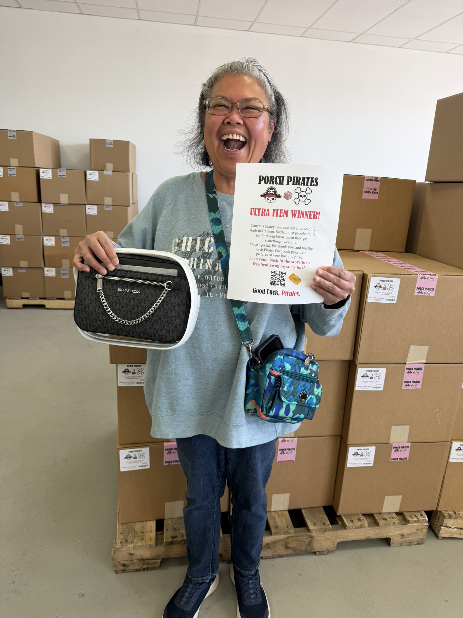 Customer laughing with a Michael Kors bag and a winner sign