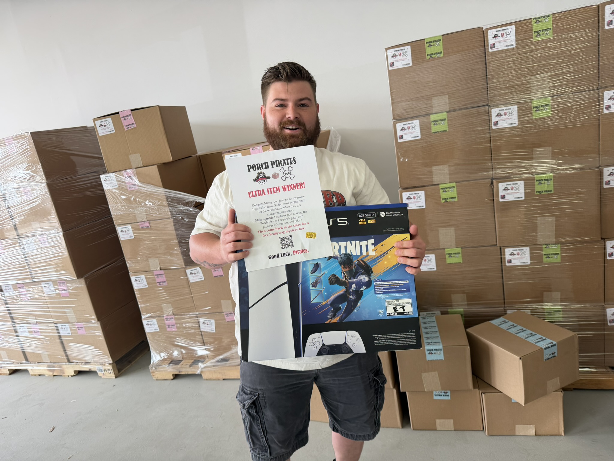 Excited customer holding a PS5 bundle and a winner sign