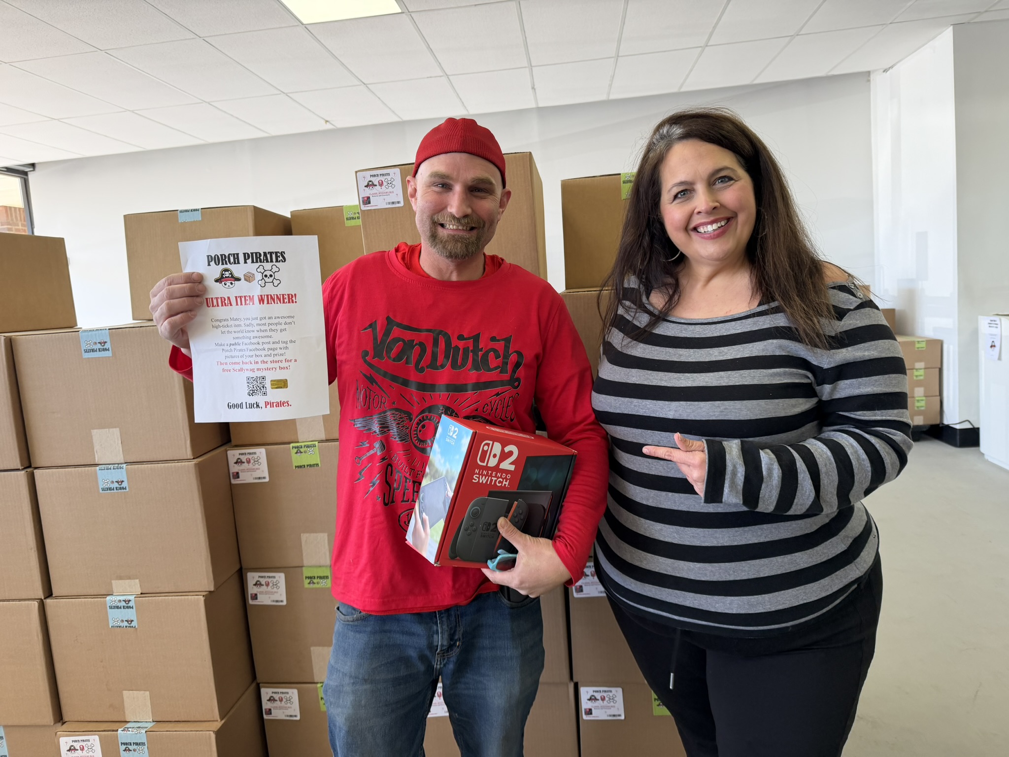 Customer holding a Switch 2 and a winner sign up high