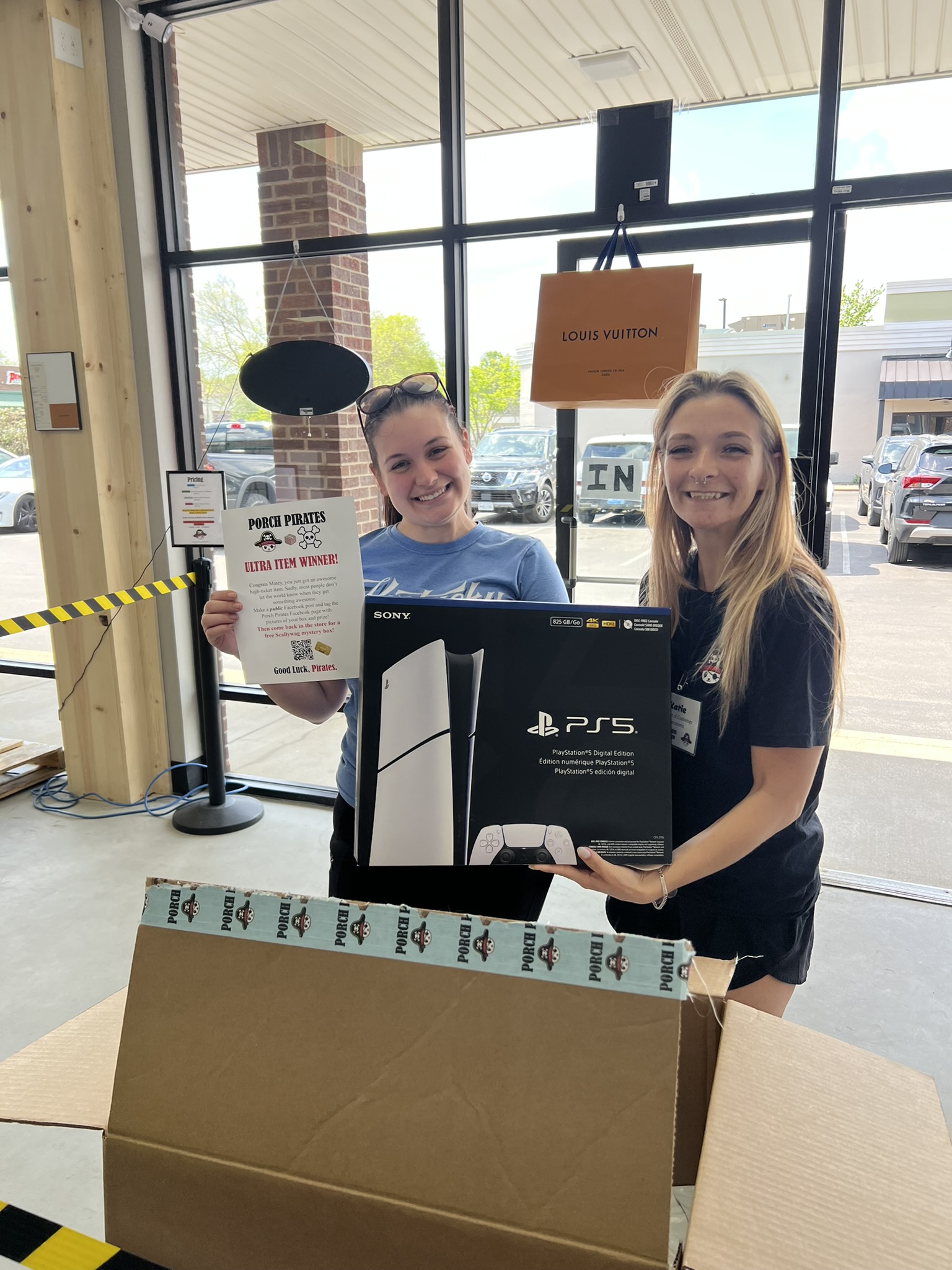 Customer and crew member holding a PS5 at the store