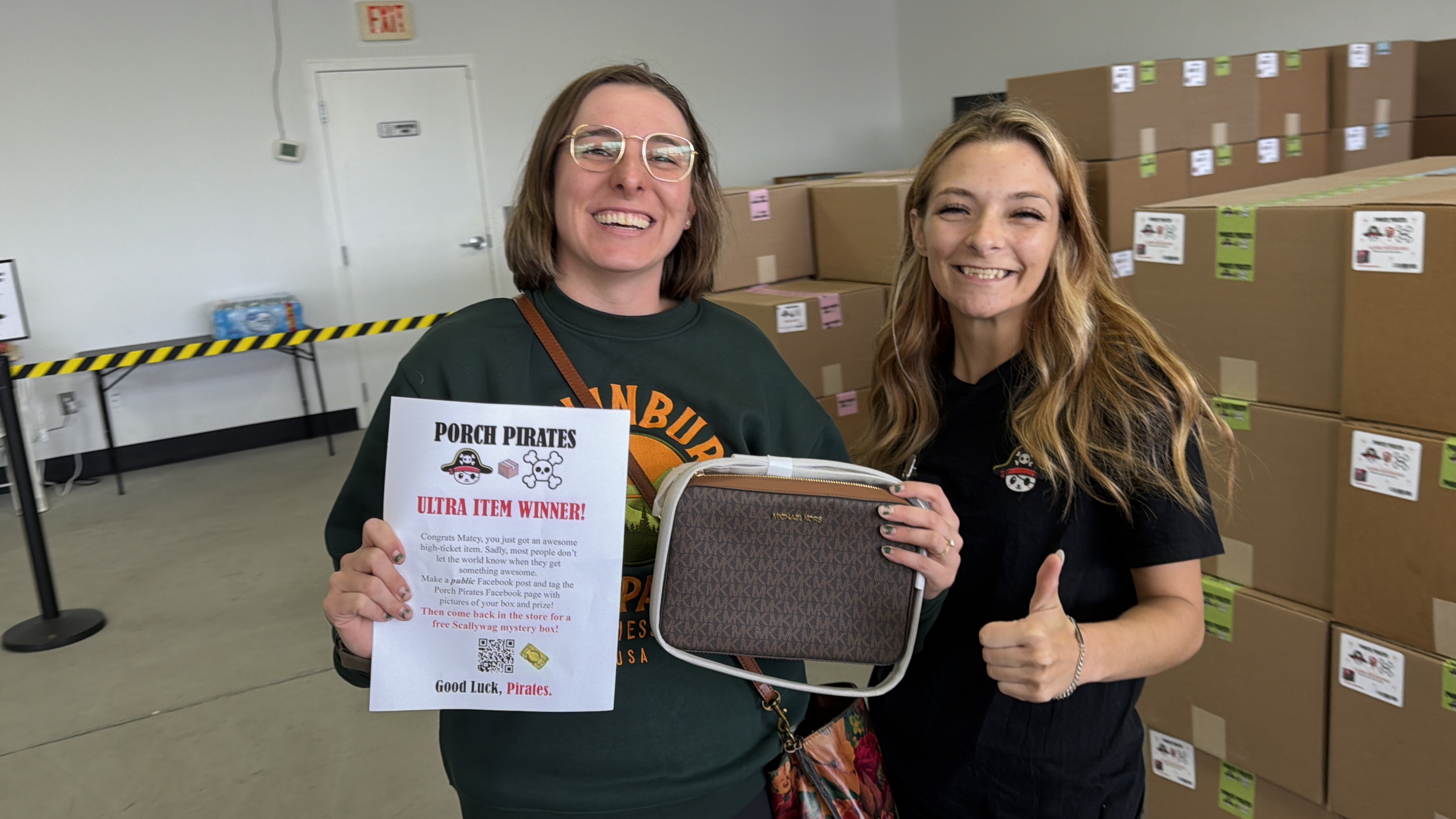Customer with a Michael Kors bag and a winner sign, crew giving thumbs up