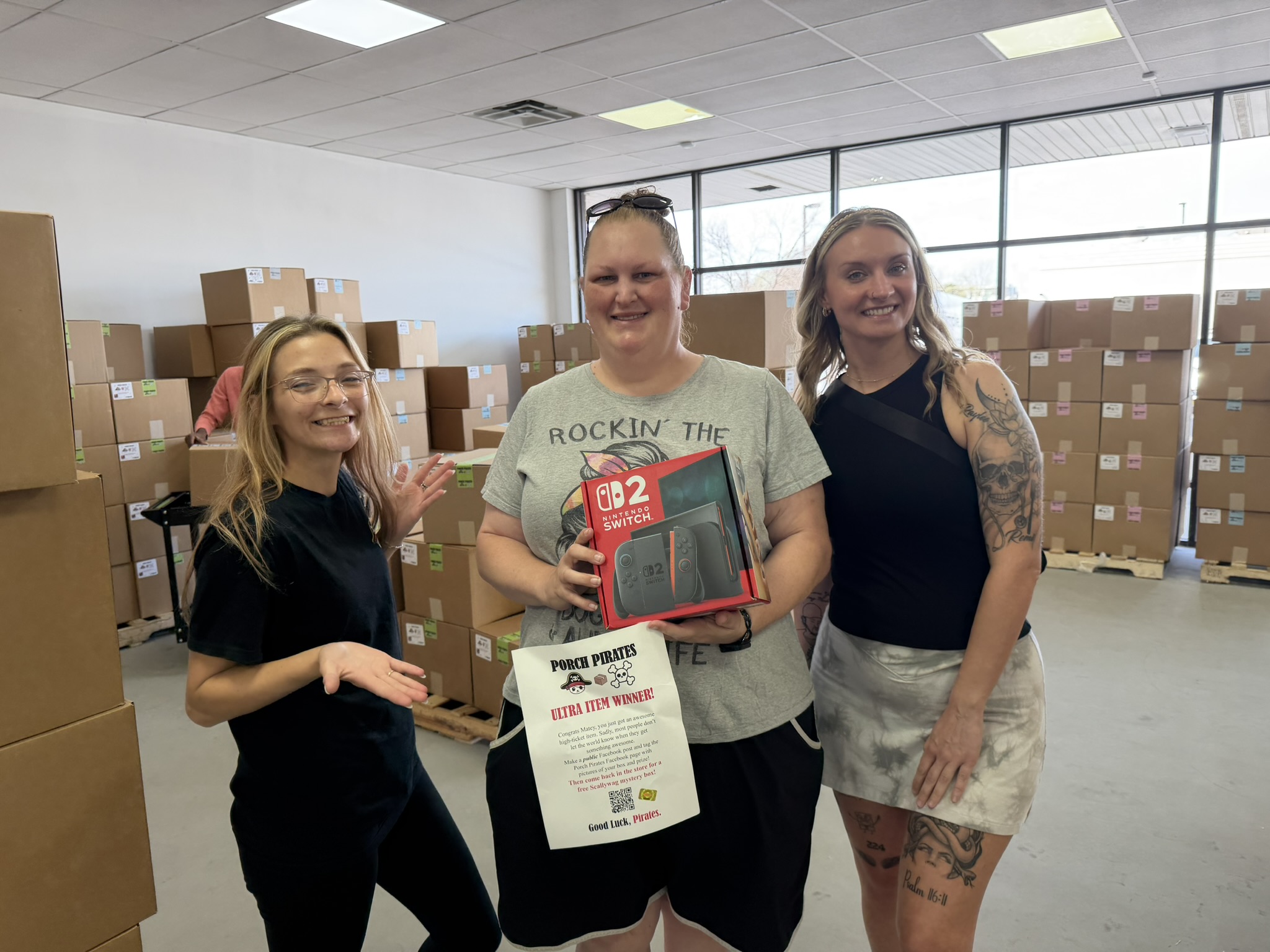 Customer holding a Switch 2 and a winner sign with two friends