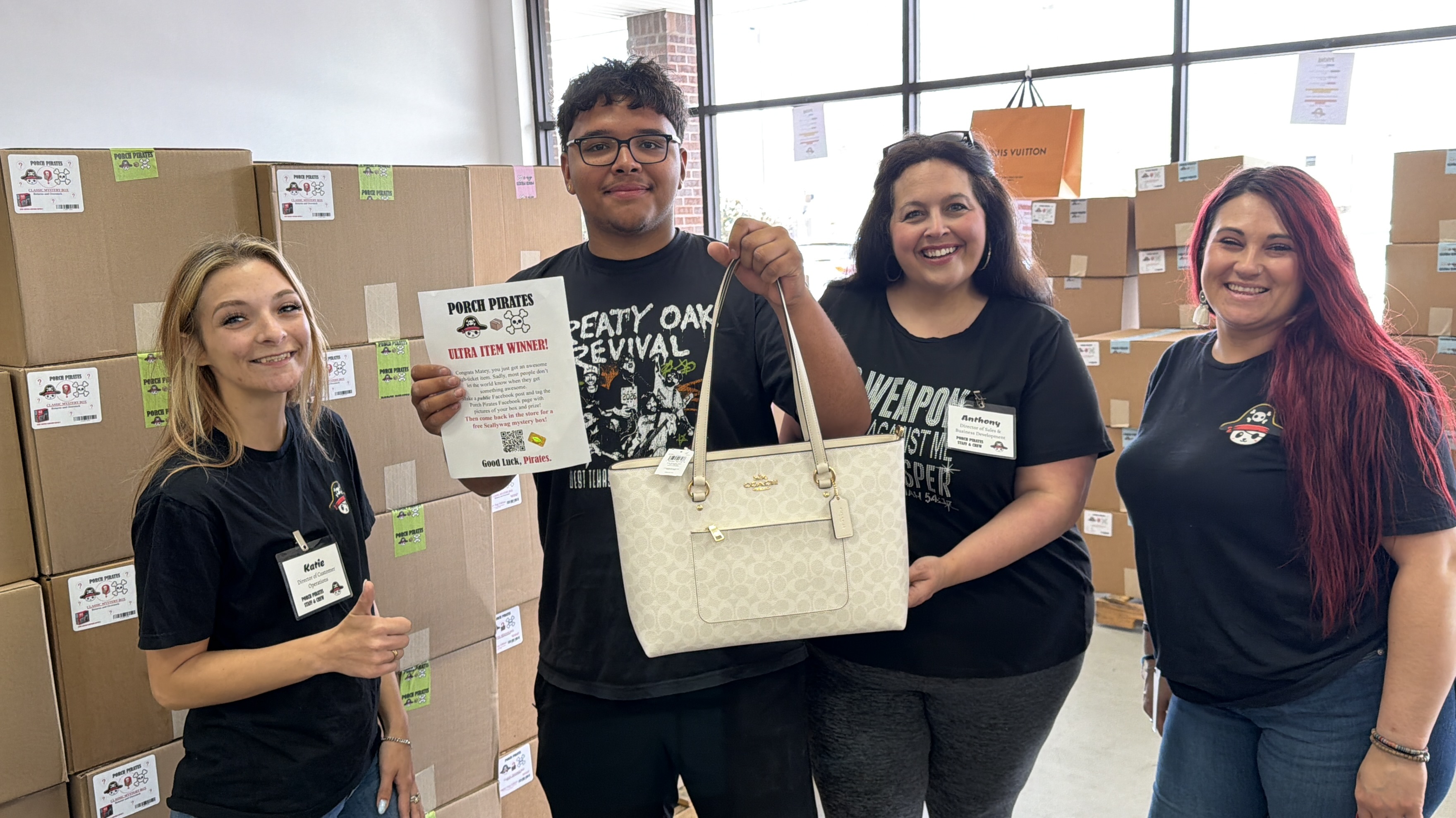 Customer holding up a Coach tote and a winner sign with the crew