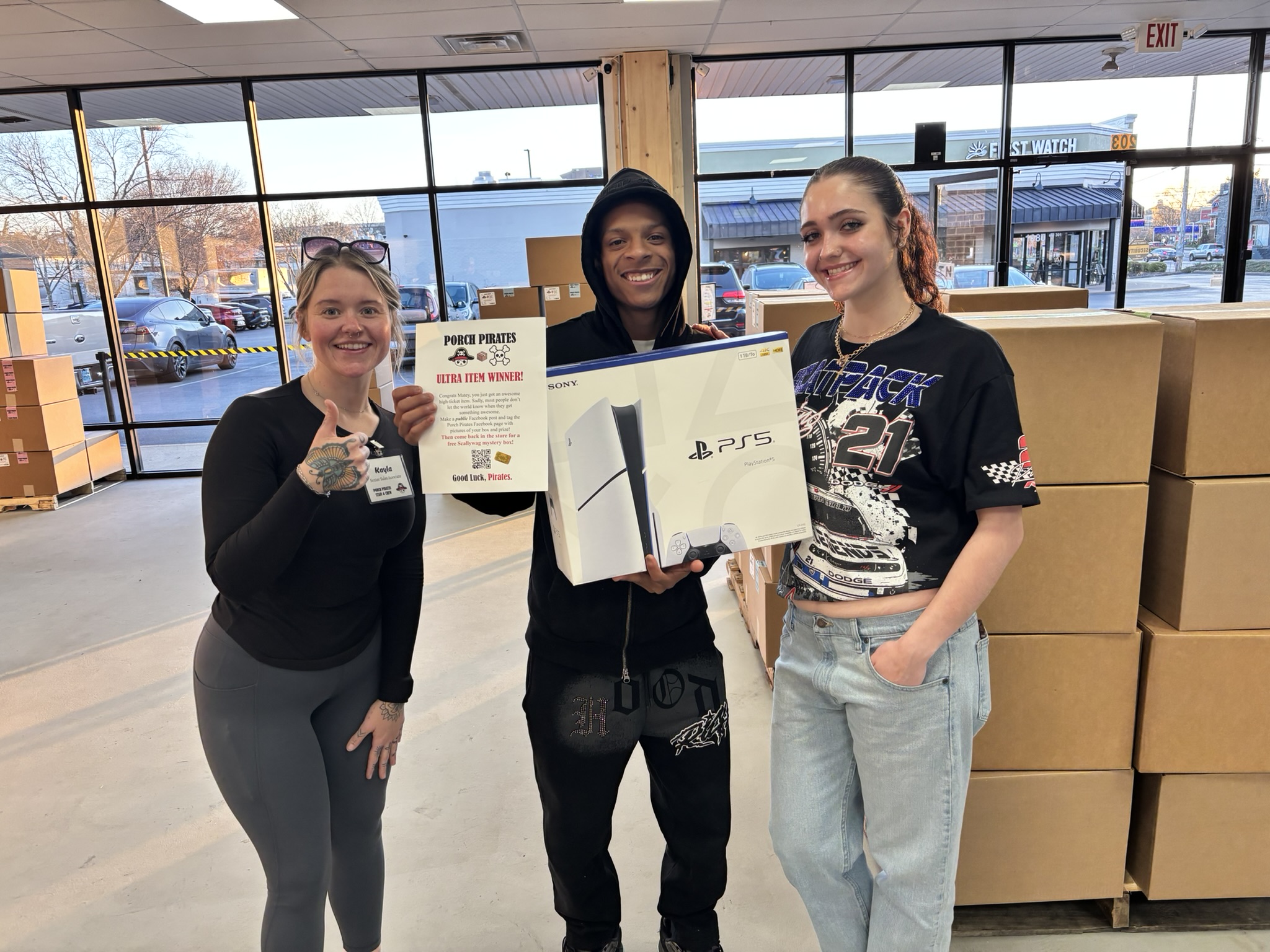 Customer holding up a PS5 and a winner sign in the store