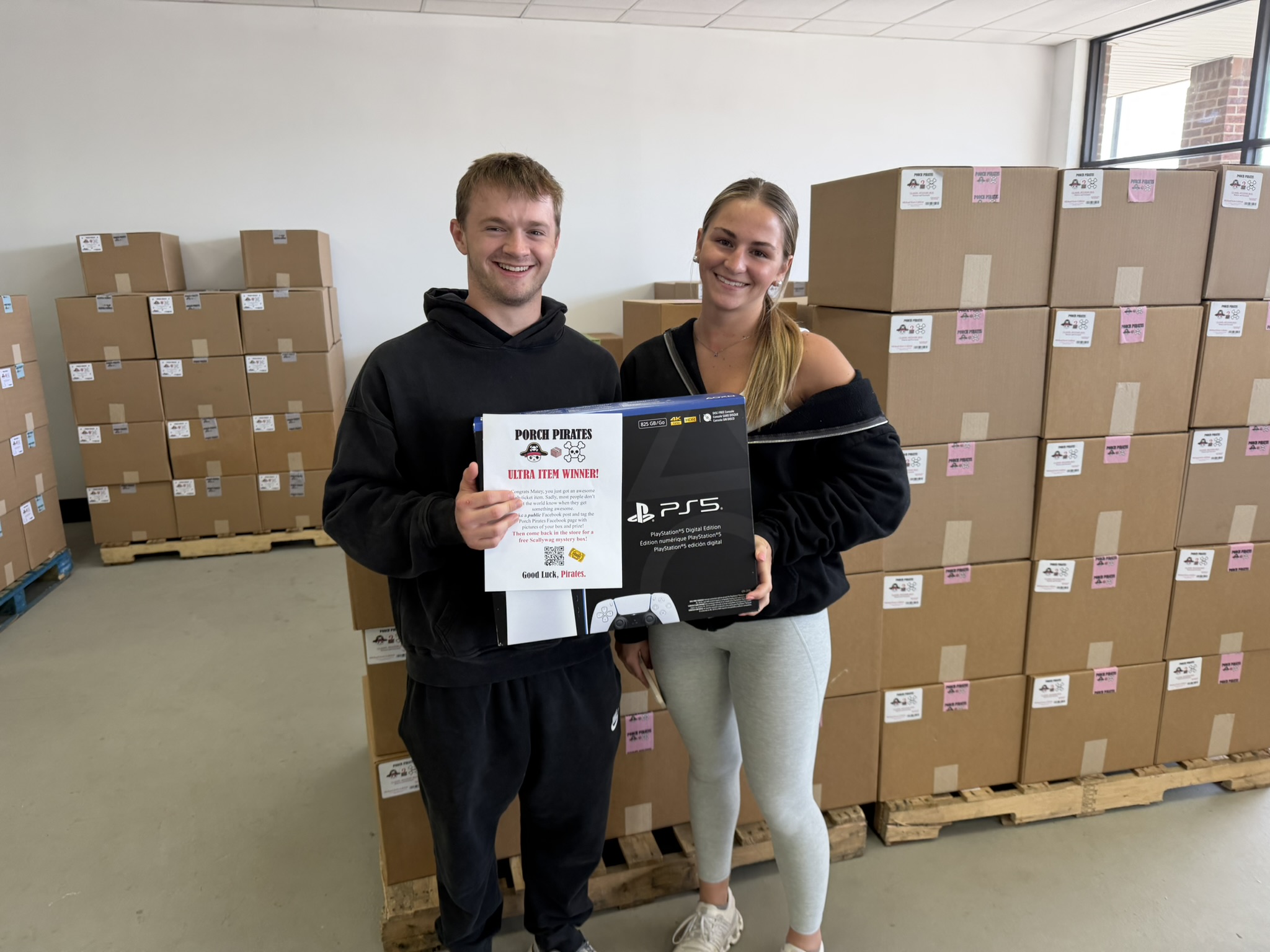 Couple holding a PS5 and an Ultra Item Winner sign