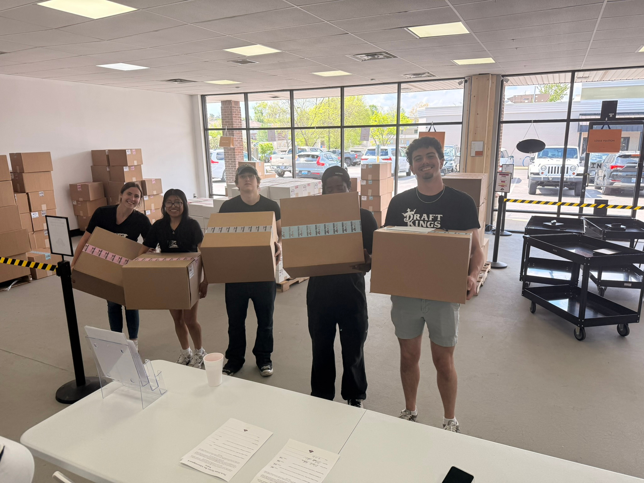 Five shoppers carrying mystery boxes across the store floor