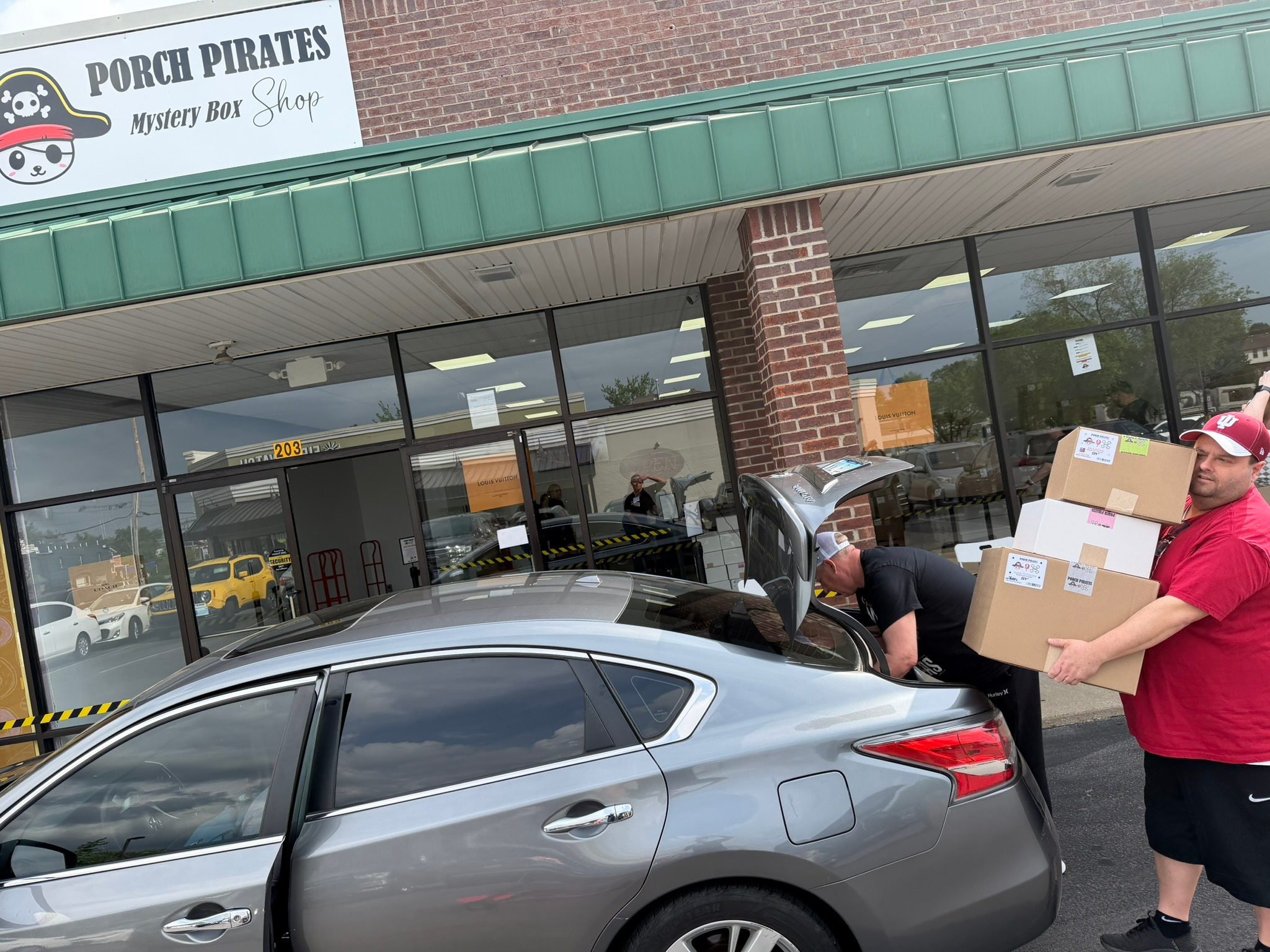 Customers loading mystery boxes into a car outside the shop