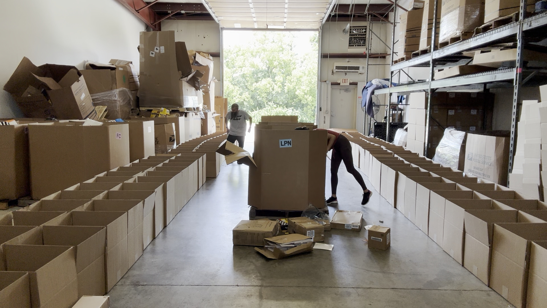Crew filling long rows of open mystery boxes on the packing line
