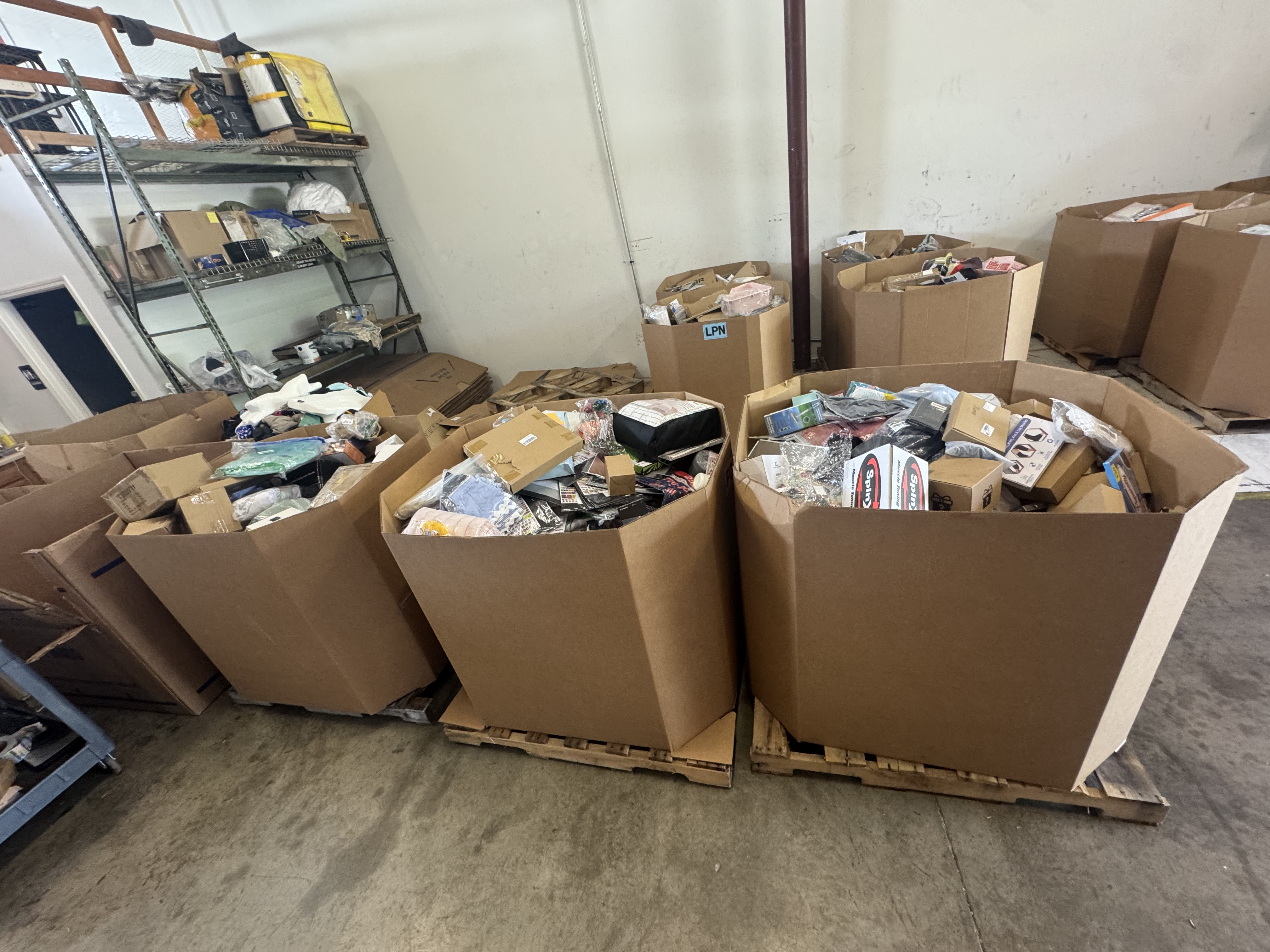 Three gaylords overflowing with returned merchandise in the warehouse