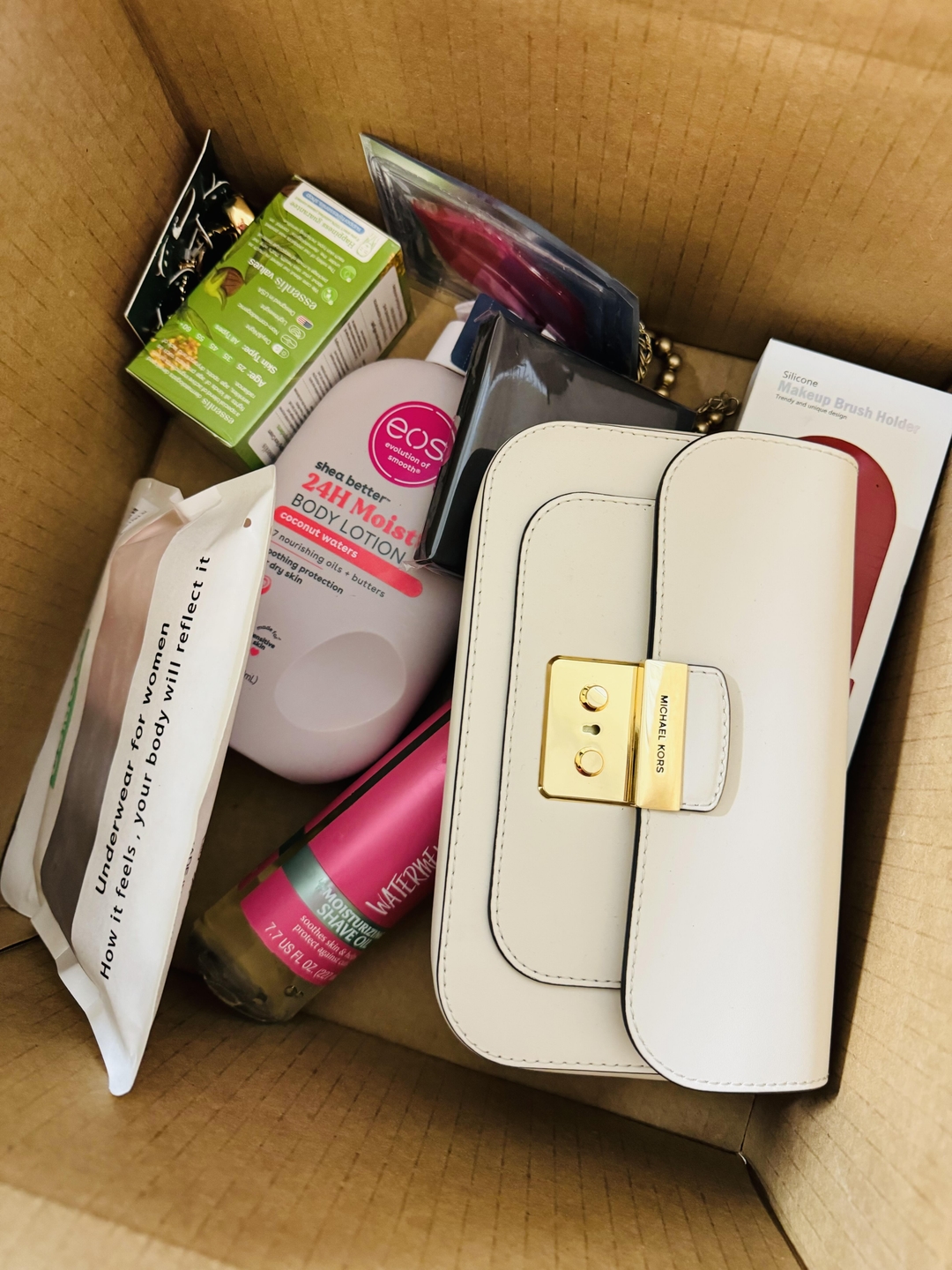 Customer photo of a white Michael Kors bag on top of a beauty haul in the box